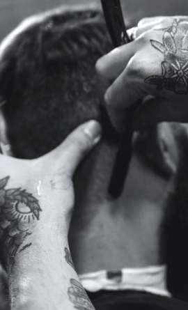 Barber applying shaving cream to customer